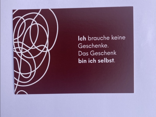 Schriftzug auf dunkelrot: Ich brauche keine Geschenke. Das Geschenk bin ich selbst.