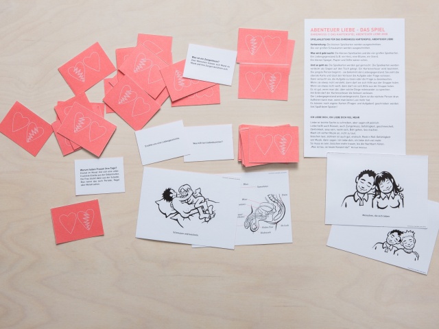 verschiedene Karten des Spiels liegen durcheinander auf einem Tisch