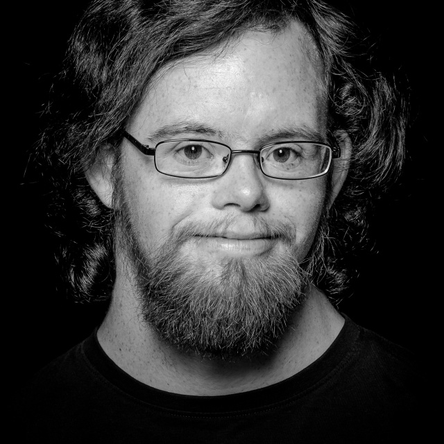 Ein schwarz-weiß Portrait von Damian Bright. Er trägt Bart und Brille.