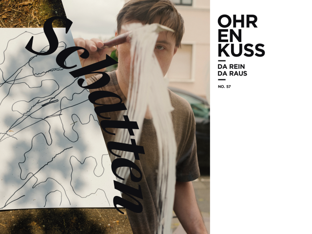 Das Cover der aktuellen Ohrenkuss-Ausgabe. Auf dem Coverfoto malt ein Mann mit Down-Syndrom eine weiße Linie an eine Glasscheibe.